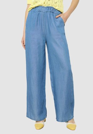 Pantalons larges bleu clair en denim doux, dotés d'une taille élastique et de poches latérales. Texture lisse avec une coupe décontractée.