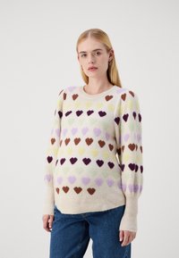 Maglione lavorato a maglia con motivi a cuore multicolori in tessuti morbidi; sfondo crema, polsini e orlo a coste, vestibilità ampia, scollatura rotonda.
