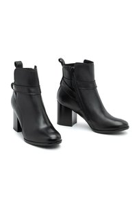 Czarne skórzane botki na kostkę z blokowym obcasem, zamkiem błyskawicznym z boku oraz ozdobnym paskiem wokół kostki. Gładka tekstura, spiczasty kształt noska.