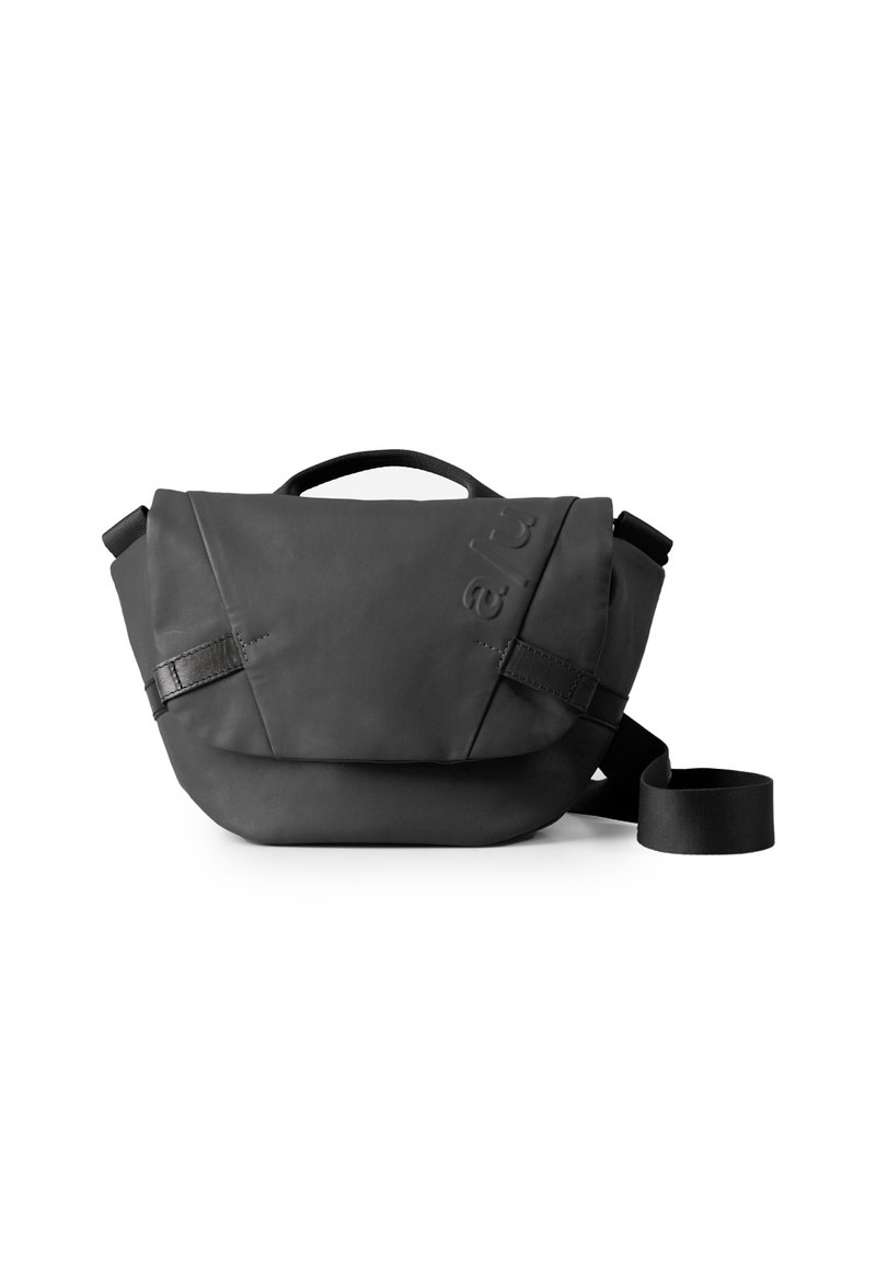 Borsa a spalla nera realizzata in materiale morbido e testurizzato. Presenta un risvolto, una tracolla regolabile e un dettaglio con logo in rilievo.