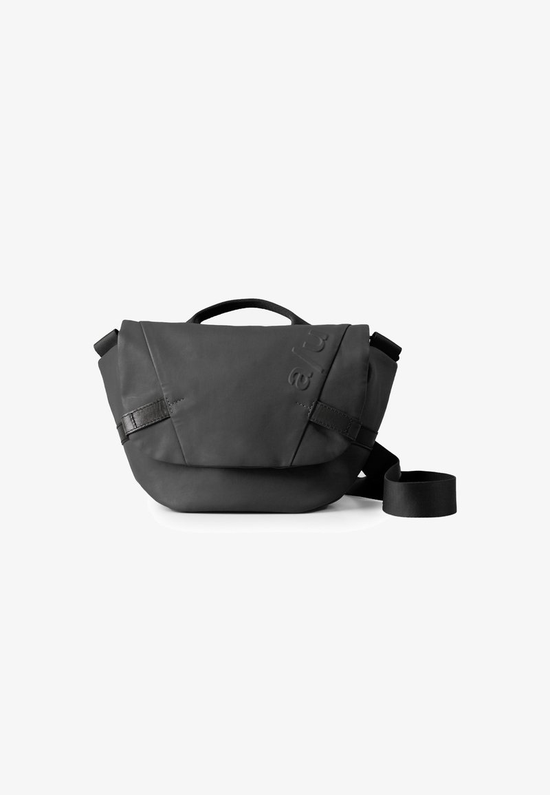 Borsa a spalla nera realizzata in materiale morbido e testurizzato. Presenta un risvolto, una tracolla regolabile e un dettaglio con logo in rilievo.