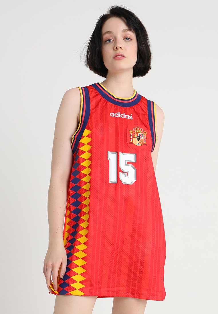 Maillot de basketball rouge avec texture en maille. Présente un motif géométrique bleu et jaune sur les côtés, un grand numéro 15, et l'emblème national espagnol.