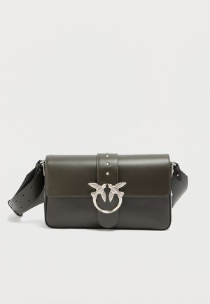 Δερμάτινη τσάντα σε σκούρο πράσινο και μαύρο, με μπροστινό κούμπωμα δύο πουλιών, ασημί εξαρτήματα και αποσπώμενο ιμάντα με τρύπες.