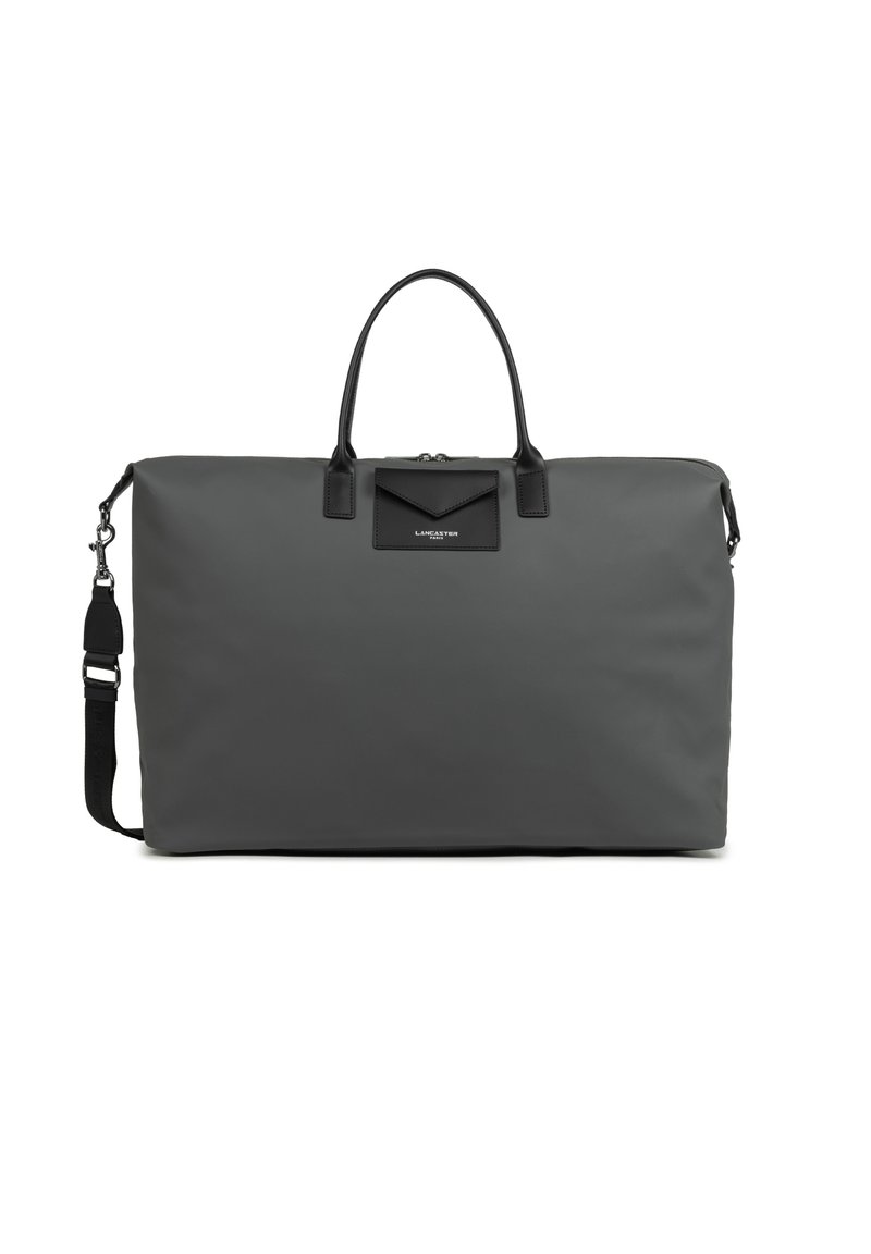 Borsa da viaggio in nylon grigio con accenti in pelle nera. Presenta due manici superiori e una tracolla rimovibile, caratterizzata da un design minimalista.