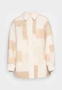 Fleece overhemdjack in crème en beige met een knoopsluiting aan de voorkant en een contrasterende kraag, met een geometrisch patroon van vierkanten.