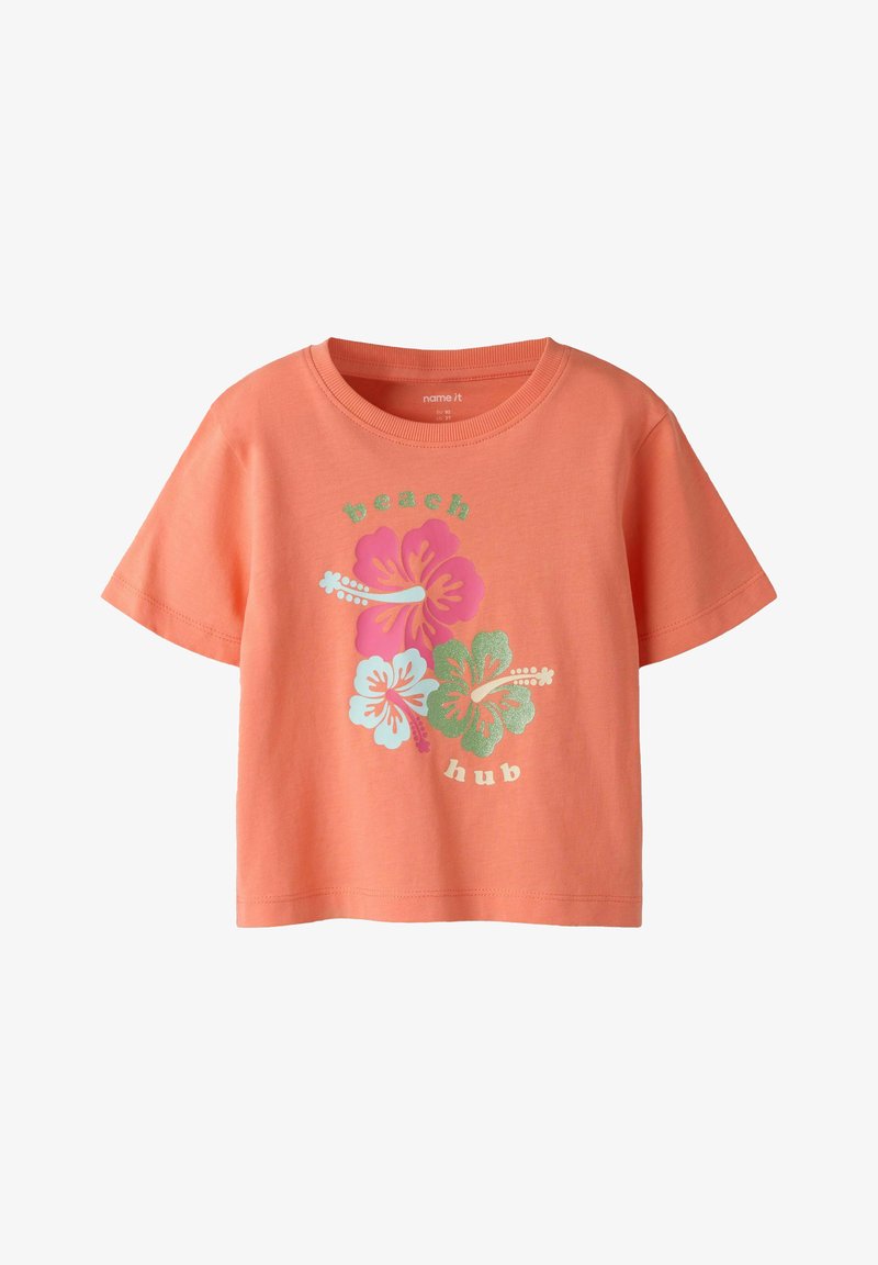 Κοραλί κοντομάνικο T-shirt με τρία λουλούδια ιβίσκου σε ροζ, λευκό και πράσινο, με το κείμενο «beach hub» πάνω και κάτω από τα λουλούδια.