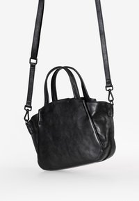 Borsa a mano in pelle nera con doppio manico superiore e una tracolla removibile. Presenta una texture morbida e una silhouette arrotondata.