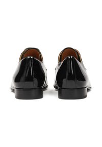 Scarpe in vernice nera con una finitura liscia, punta arrotondata, tacco basso e design minimalista. L'interno presenta un rivestimento beige.