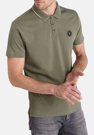 Polo olive avec un col côtelé, une patte de boutonnage à trois boutons et un patch logo. Des manches courtes et des fentes sur les côtés renforcent le confort.