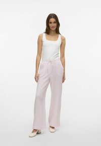 Vit fyrkantig halsringning linne i kombination med ljusrosa rutiga vida byxor med elastisk midja och dragsko. Slät tygtextur.