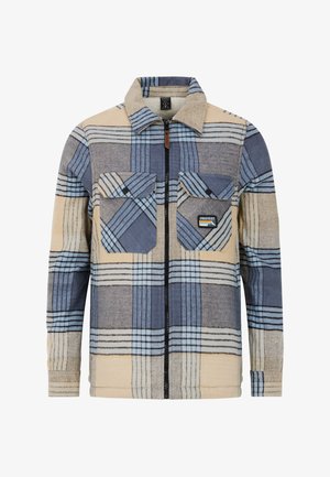 Koszula z flaneli z zamkiem w kolorze kremowym i niebieskiej kratce. Posiada dwie kieszenie na piersi, kołnierz zapinany na guziki oraz czarny zamek.