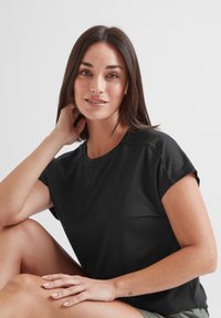 Black short-sleeve athletic top with a round neckline and textured shoulder panels, made from a smooth, breathable fabric.