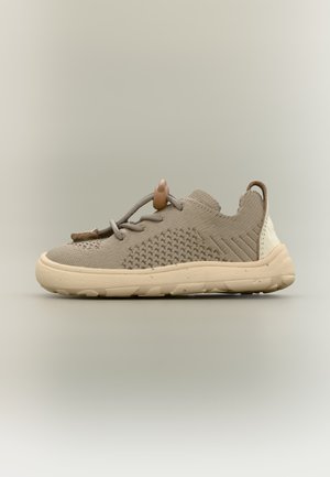 Jasnobrązowy dziergany tenisówka z teksturowanym wzorem, beżową podeszwą i zapięciem na zatrzask na jednolitym neutralnym tle.