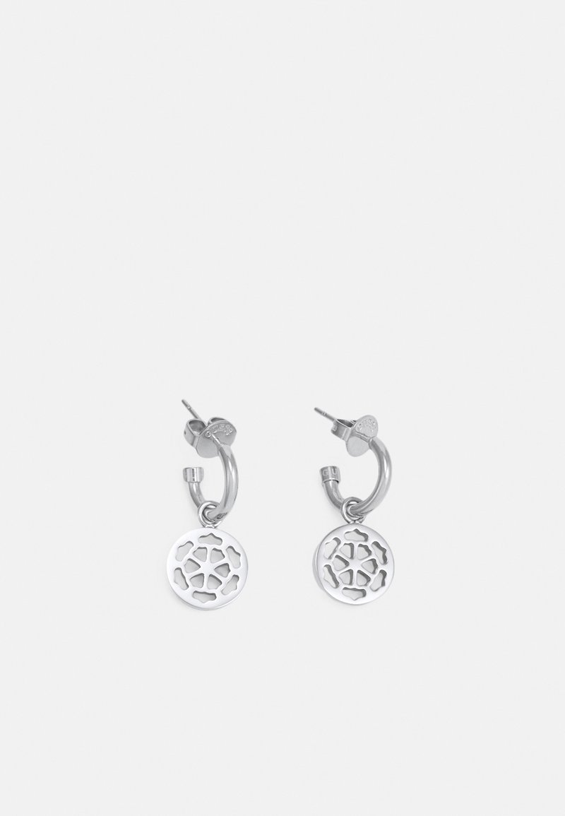 Boucles d'oreilles anneaux en argent avec pendentifs circulaires affichant un motif floral géométrique découpé, exposées sur un fond clair uni.