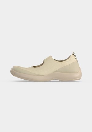 Beige slip-on sneaker with knit upper, rounded toe, thick sole, and pull tab at heel, designed for casual wear.