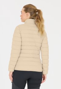 Beige puffjakke med vandret quiltet design, høj krave og figursyet pasform. Taperede ærmer og blød tekstur.