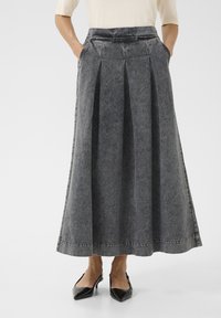 Grauer Denim-Maxikleid mit Falten, seitlichen Taschen und einem Bund. Abschließende Merkmale sind sichtbare Nähte und ein gerader Saum.