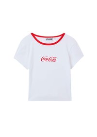 T-shirt bianco a maniche corte con colletto rosso e logo "Coca-Cola" rosso centrato sul davanti. Realizzato in un materiale simile al cotone, morbido al tatto.