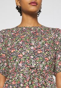 Vestito floreale con base nera e motivi rosa e verdi, maniche corte a palloncino e scollatura arricciata. Tessuto morbido.