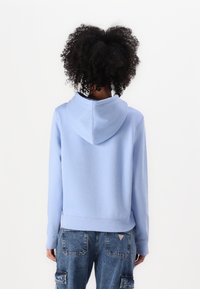 Ανοιχτό μπλε φούτερ με κουκούλα φτιαγμένο από απαλό ύφασμα, με χαλαρή εφαρμογή, ριμπ μανσέτες και περικοπή, καθώς και χωρίς ραφή σχεδίαση στην κουκούλα.