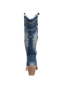 Bota vaquera de denim con punta afilada, costuras decorativas en oro, textura desgastada y un tacón medio en bloque. El diseño incluye tiradores.