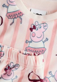 Svetloružový pyžamový set z mäkkého fleece s postavičkou Peppy Pig v baletnej súprave, s volánikmi na rukávoch a pruhovaným pozadím.