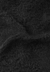 Nahaufnahme eines weichen schwarzen Stoffs mit einer flauschigen Textur und einem subtilen Webmuster.