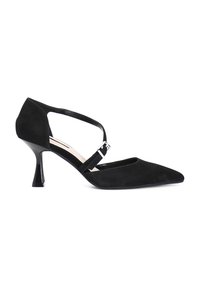 Zapato de tacón alto de ante negro con punta afilada, correa al tobillo y un tacón esculpido único. Presenta un acento de hebilla plateada brillante.