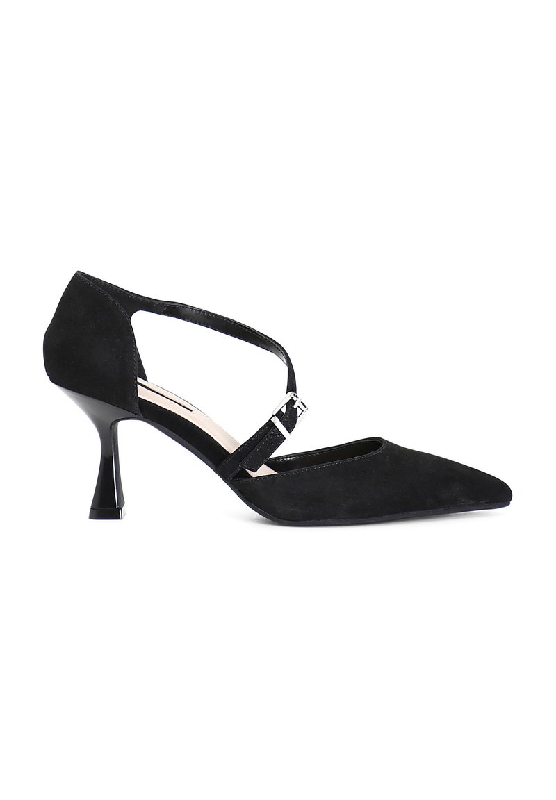 Zapato de tacón alto de ante negro con punta afilada, correa al tobillo y un tacón esculpido único. Presenta un acento de hebilla plateada brillante.