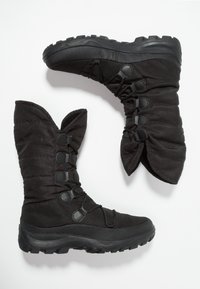 Botas de invierno negras con tela acolchada y suelas de goma. Presentan una caña alta, cordones ajustables y detalles texturizados. Diseño plano y duradero.