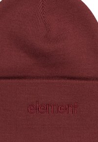 Burgundy knit beanie made of soft fabric, featuring a rolled cuff and subtle logo embroidery, highlighting smooth texture and simple design.
