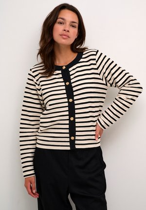 Striped cardigan in cream and black fabric, featuring gold buttons down the front and a ribbed texture. Long sleeves and round neckline.