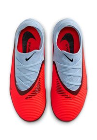 Scarpe sportive rosse e azzurre chiaro con una tomaia testurizzata, un prominente logo Nike Swoosh nero e un motivo a strisce unico lungo i lati.