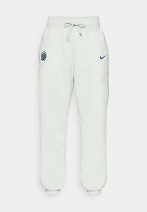 Light grey sweatpants with an elastic waistband, drawstring, cuffed ankles, and a navy emblem featuring a logo on the left thigh.