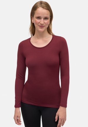 Top de manga larga burdeos hecho de una tela suave y elástica con un cuello redondo. Diseño ajustado con una textura lisa y sin patrones visibles.