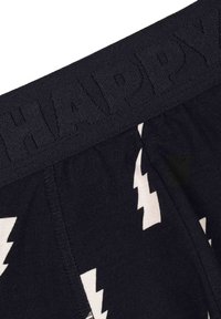 Crne bokserice s teksturiranim pojasom u kojem je utisnuta riječ "SRETNO." Ukrašene su bijelim munjama na mekom materijalu.