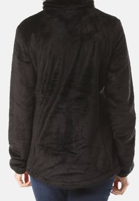 Schwarze Fleecejacke mit hohem Kragen, weicher Textur und geschwungenem Saum. Verfügt über lange Ärmel und ein kleines Logo in der Nähe des Halses.