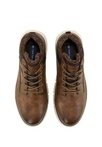 Brune lædersko med en struktureret overflade, kunstpelsforing, rund tå og grå snørebånd. Den hvide gummisål giver kontrast.