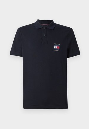 Polo blu navy a maniche corte con due bottoni e piccolo logo Tommy Hilfiger e "1985" sul lato sinistro del petto.
