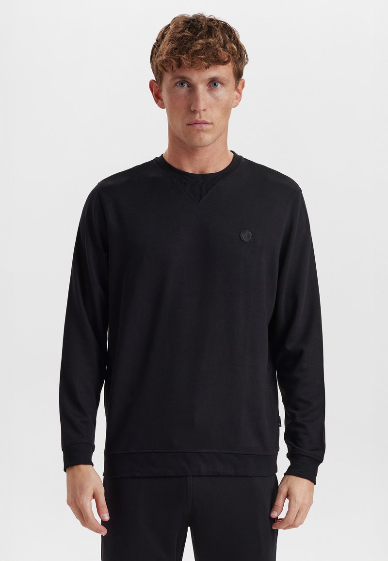 Sort langærmet sweatshirt med V-hals og ribbede manchetter. Har et rundt logo-patch på brystet; lavet af blødt stof.