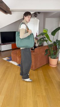 Πράσινη υφασμάτινη τσάντα ώμου με δομημένο σχέδιο; διαθέτει δερμάτινη ταφή σε καφέ απόχρωση, ευρύχωρο εσωτερικό και ανθεκτικές ιμάντες στον ώμο.
