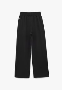 Pantalones negros de pierna ancha hechos de una tela suave con cintura elástica. Presenta un pequeño detalle de logo cerca de la cintura, sin patrones visibles.