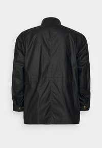 Svart vattentät jacka med hög krage, långa ärmar och tryckknappsdetaljer. Har en texturerad yta och sömdetaljer.