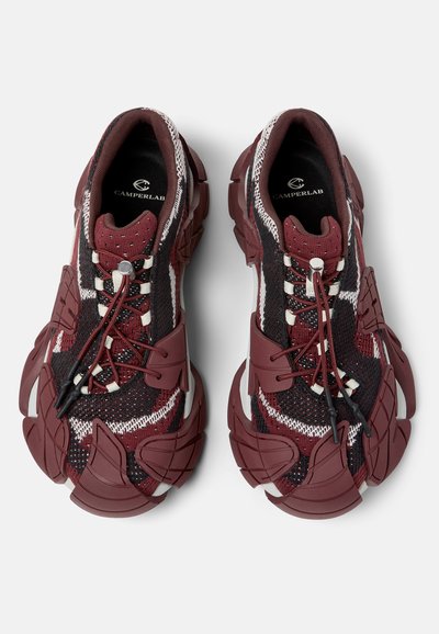 Baskets en maille rouge et noire avec semelles sculptées épaisses et lacets élastiques sans nouer, marquées CamperLab à l'intérieur du talon.