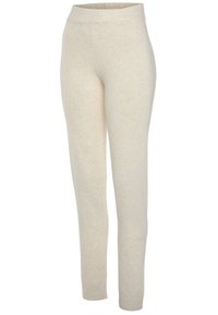 Beige legging gemaakt van zachte stof, met een geribde tailleband en een gladde textuur. Het ontwerp is aansluitend en taps toelopend bij de enkels.