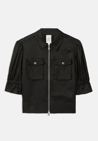 Must have musta varrukatega jaki, millel on krae, lukuga esiosa, kaks rinda taskut ja kogutud varrukad, mis on valmistatud siledast kangast.