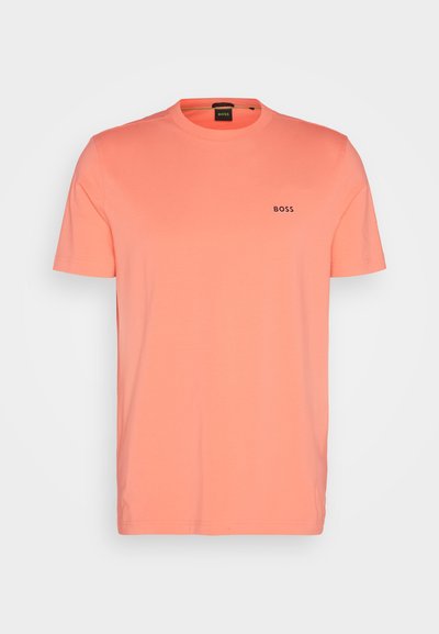 T-shirt à manches courtes de couleur corail vif, en coton doux. Il présente un col rond et un petit logo noir "BOSS" sur la poitrine.
