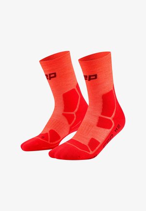 Paar leuchtend roter und orangefarbener Sportsocken mit gepolsterten Bereichen und Markenlogos, entwickelt für Sport- oder athletische Zwecke.