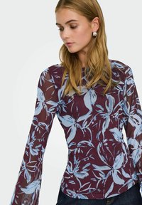 Langærmet bluse i gennemsigtigt bordeaux stof med et blåt blomstertryk. Har en tætsiddende form og flagrende ærmer, der fremhæver teksturen.