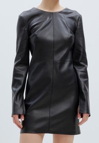 Zwart leren jurk met lange mouwen, ronde halslijn, getailleerde silhouet en zichtbare stiksels, gladde textuur, minimalistisch ontwerp.